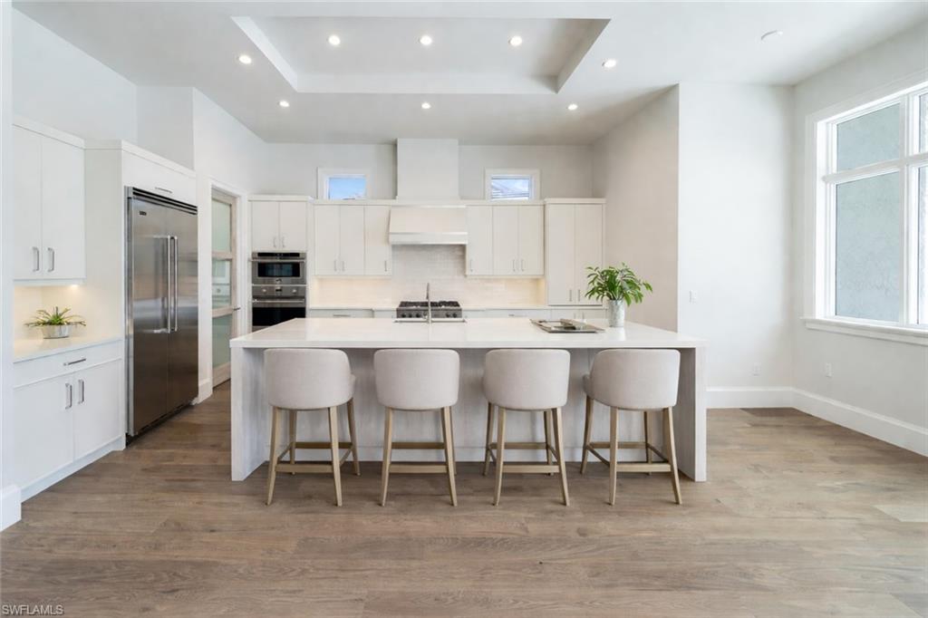 16716 Enclave Circle Naples, FL 34110 - Photo 7 of 50 Kitchen featuring tasteful backsplash, a breakfast bar area, a large island, stainless steel appliances, and recessed lighting