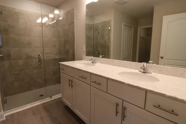 a bathroom with a sink double vanity and shower