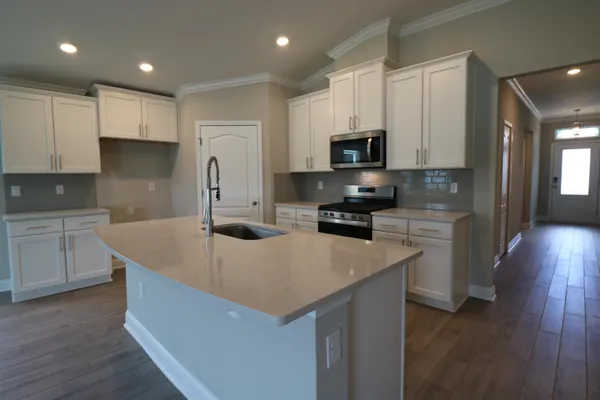 a kitchen with granite countertop a sink stove and refrigerator
