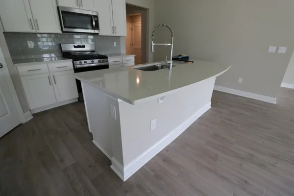 a kitchen with stainless steel appliances granite countertop a sink a stove and a microwave