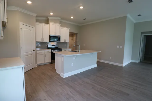 a view of kitchen with cabinets microwave and stove