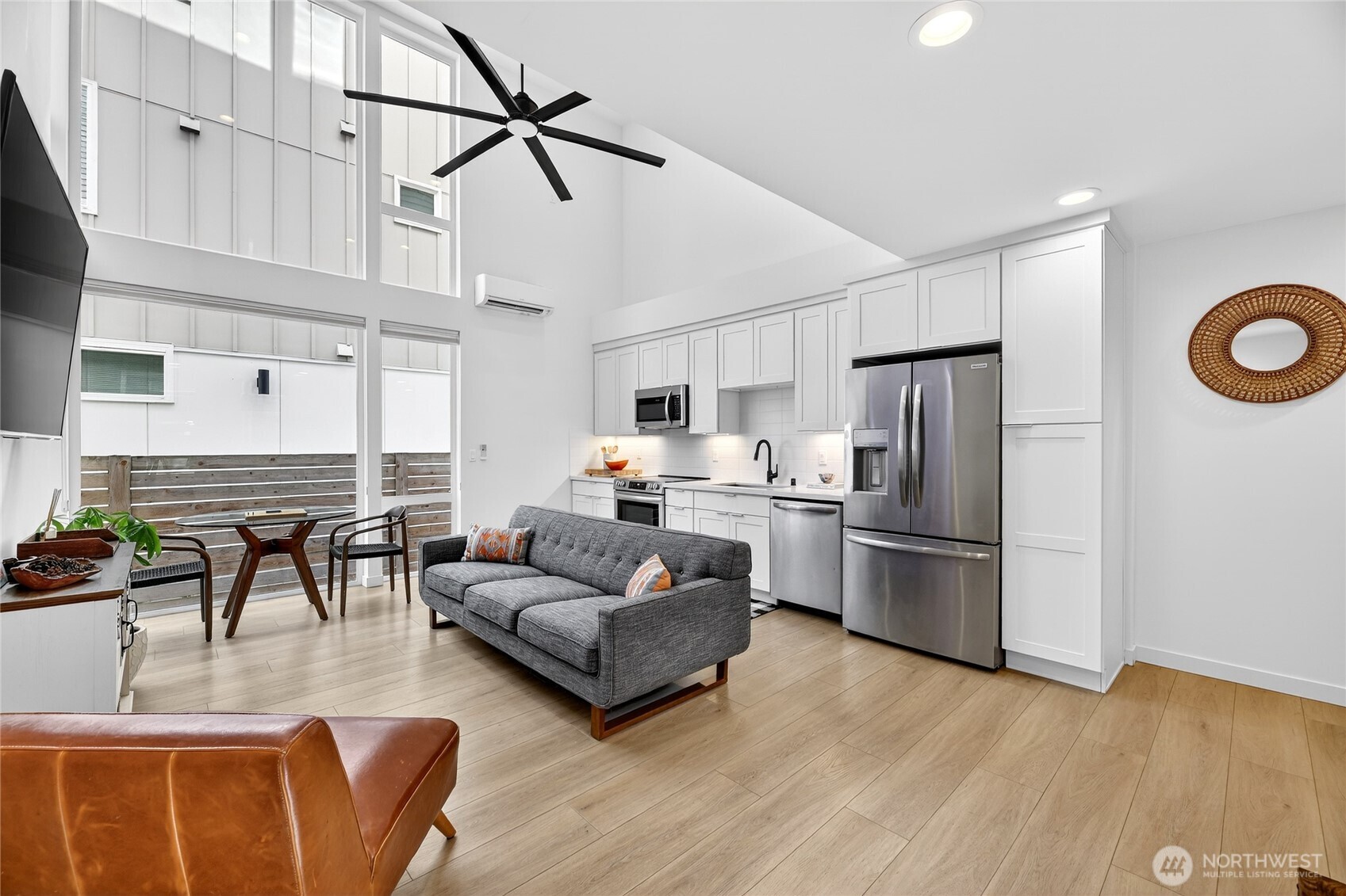 6320 41st Avenue Southwest, Unit B Seattle, WA 98136 - Photo 4 of 31 a kitchen with stainless steel appliances granite countertop a refrigerator a stove a sink dishwasher and white cabinets with wooden floor