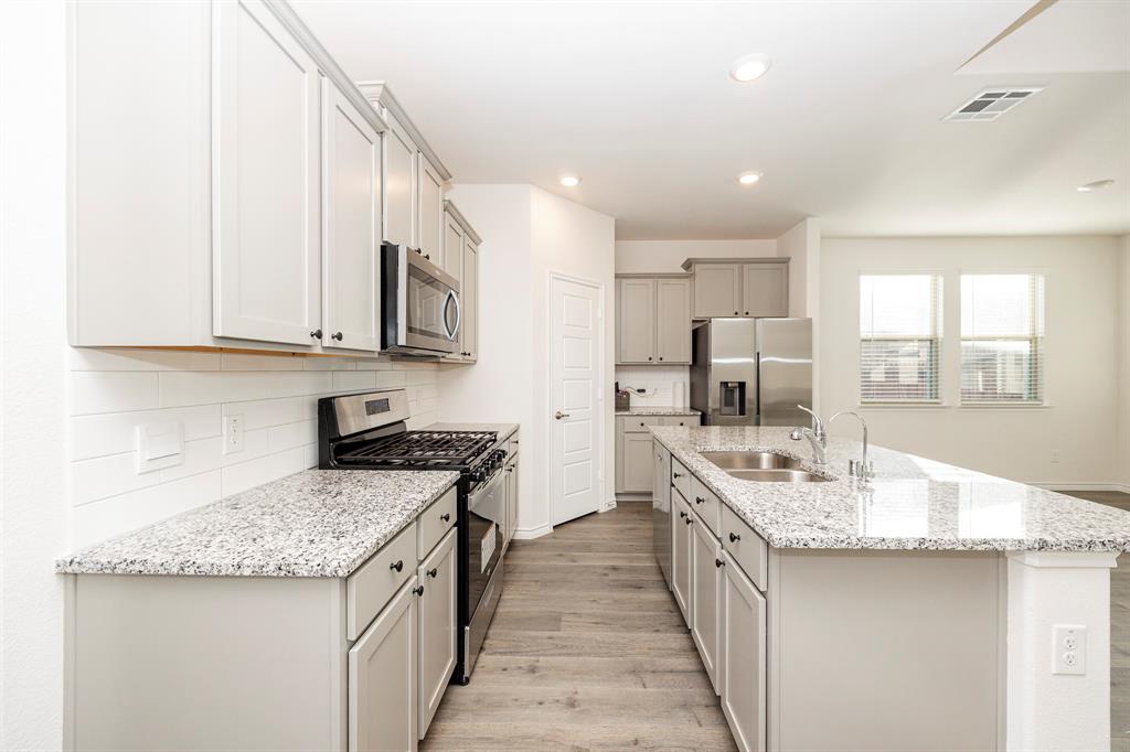 1001 Marigold Street Princeton, TX 75407 - Photo 13 of 37 a large kitchen with stainless steel appliances granite countertop a sink stove and refrigerator