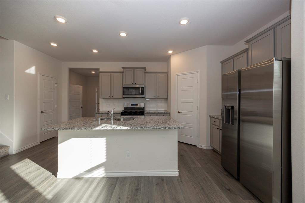 1001 Marigold Street Princeton, TX 75407 - Photo 23 of 37 a kitchen with stainless steel appliances granite countertop a refrigerator and a stove top oven