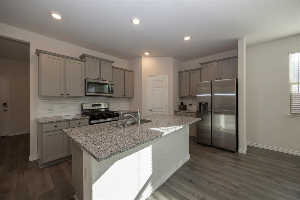 1001 Marigold Street Princeton, TX 75407 - Photo 24 of 37 a kitchen with stainless steel appliances granite countertop a sink stove and refrigerator