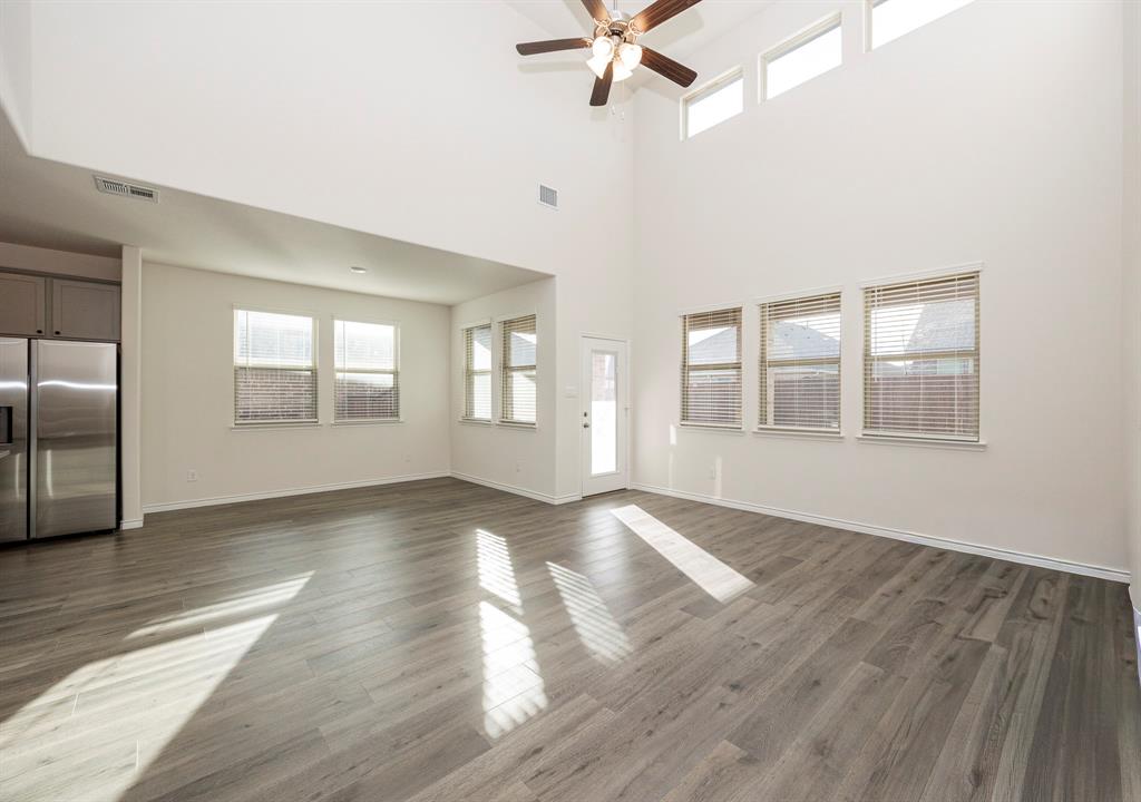 1001 Marigold Street Princeton, TX 75407 - Photo 5 of 37 an empty room with wooden floor fan and windows