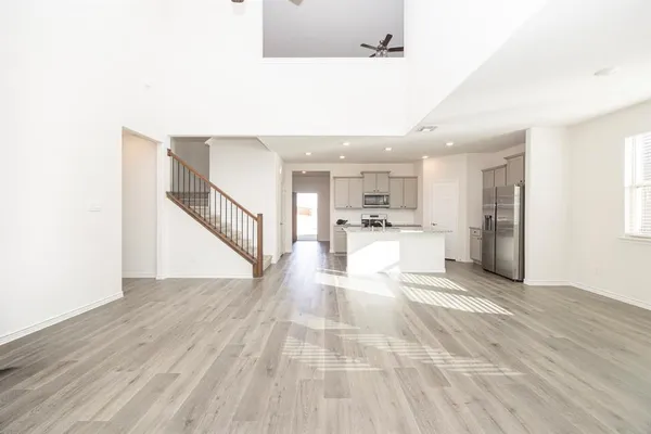 a view of a living room with kitchen island stainless steel appliances wooden floor and view living room