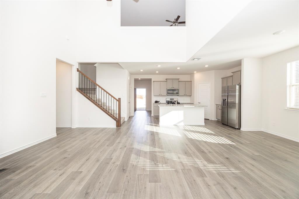 1001 Marigold Street Princeton, TX 75407 - Photo 9 of 37 a view of a living room with kitchen island stainless steel appliances wooden floor and view living room