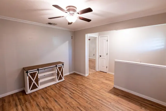 a view of a kitchen with a stove cabinets a ceiling fan and wooden floor