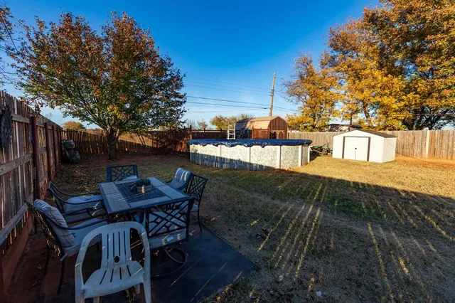 a view of a patio with table and chairs with wooden floor and fence