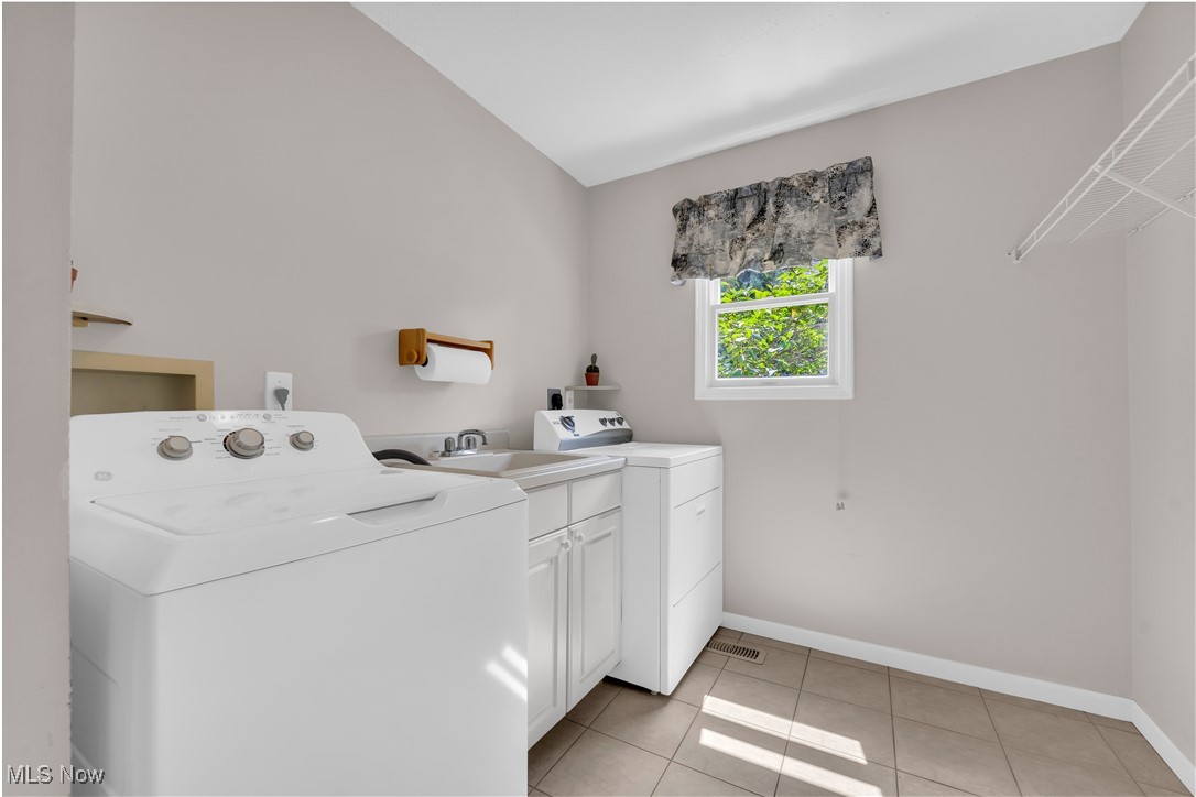 8651 State Road North Royalton, OH 44133 - Photo 23 of 33 Washroom with light tile patterned floors, cabinet space, and independent washer and dryer