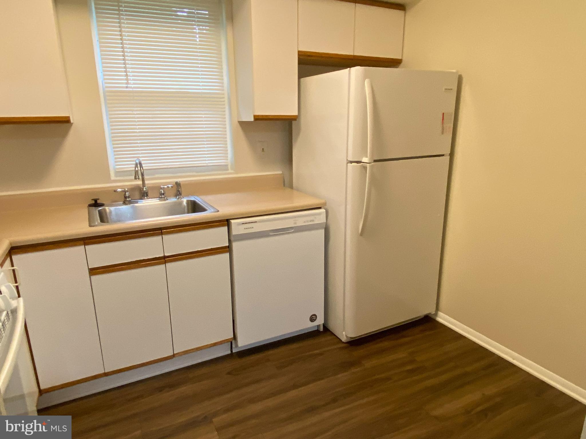 11914 J Tarragon Road, Unit J Reisterstown, MD 21136 - Photo 7 of 11 a kitchen with a sink a refrigerator a window and cabinets