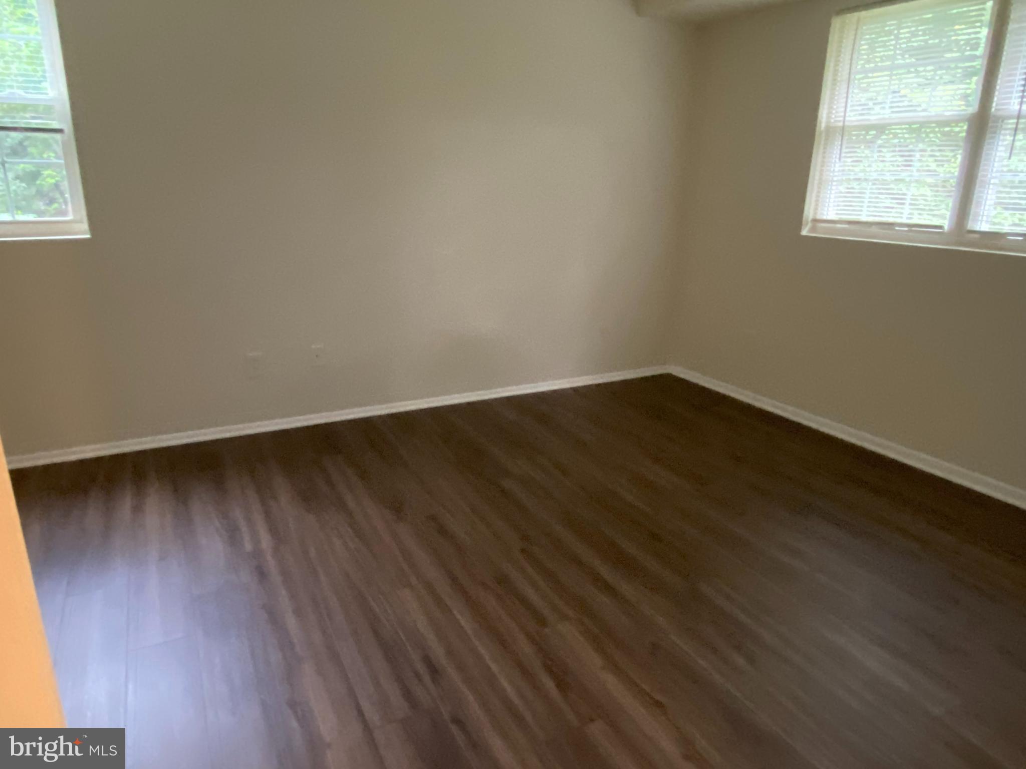 11914 J Tarragon Road, Unit J Reisterstown, MD 21136 - Photo 9 of 11 an empty room with wooden floor and windows