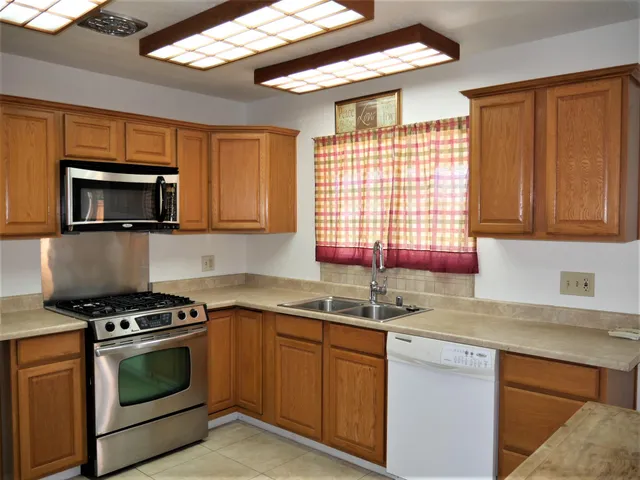 a kitchen with stainless steel appliances a stove sink microwave and cabinets