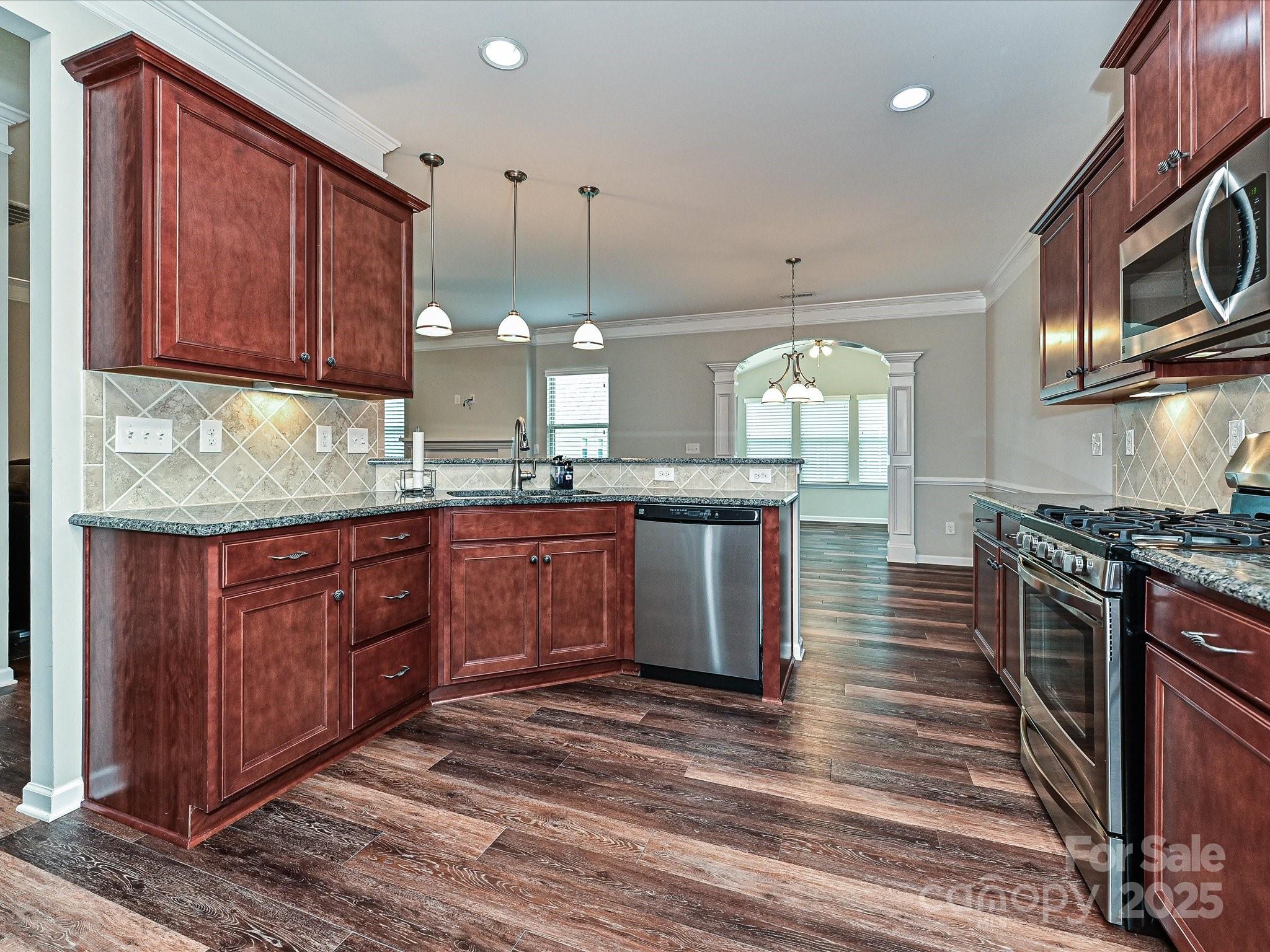 4425 Marlay Park Indian Trail, NC 28079 - Photo 12 of 33 a kitchen with stainless steel appliances granite countertop wooden cabinets a stove top oven a sink and dishwasher