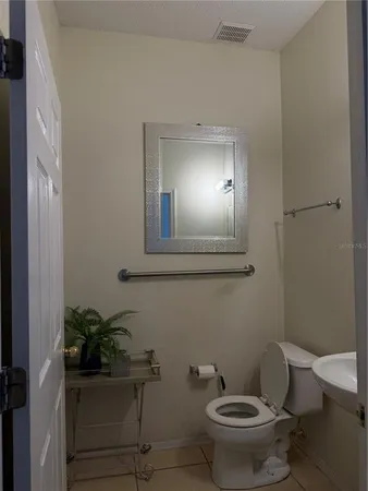 a bathroom with a toilet a sink and mirror