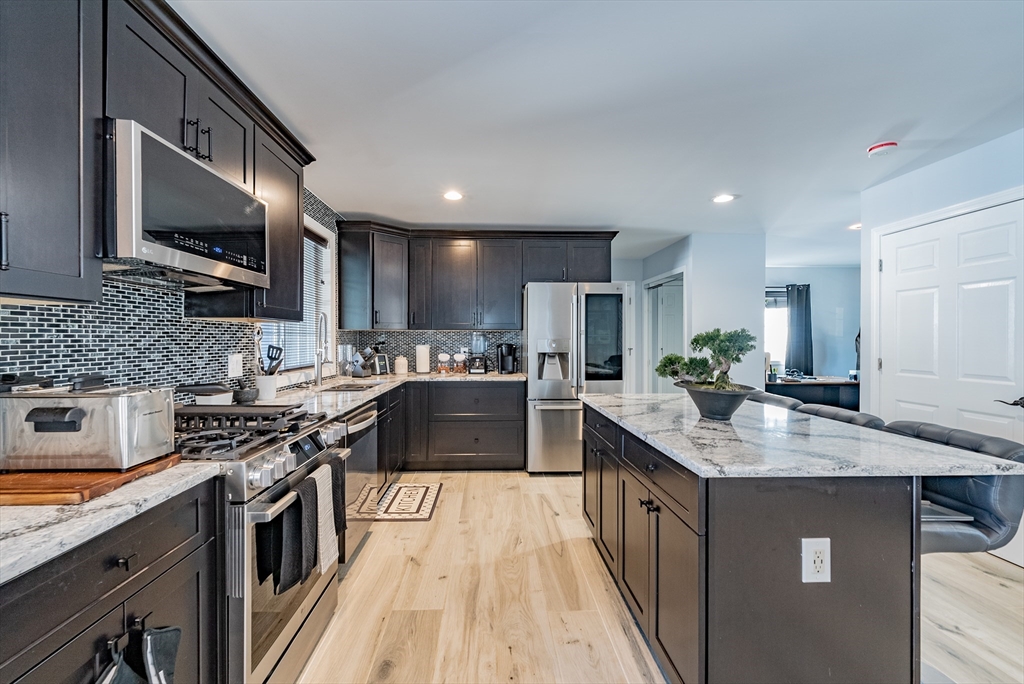 42 Ringgold Street Springfield, MA 01107 - Photo 8 of 13 a kitchen with stainless steel appliances granite countertop wooden cabinets sink stove and microwave