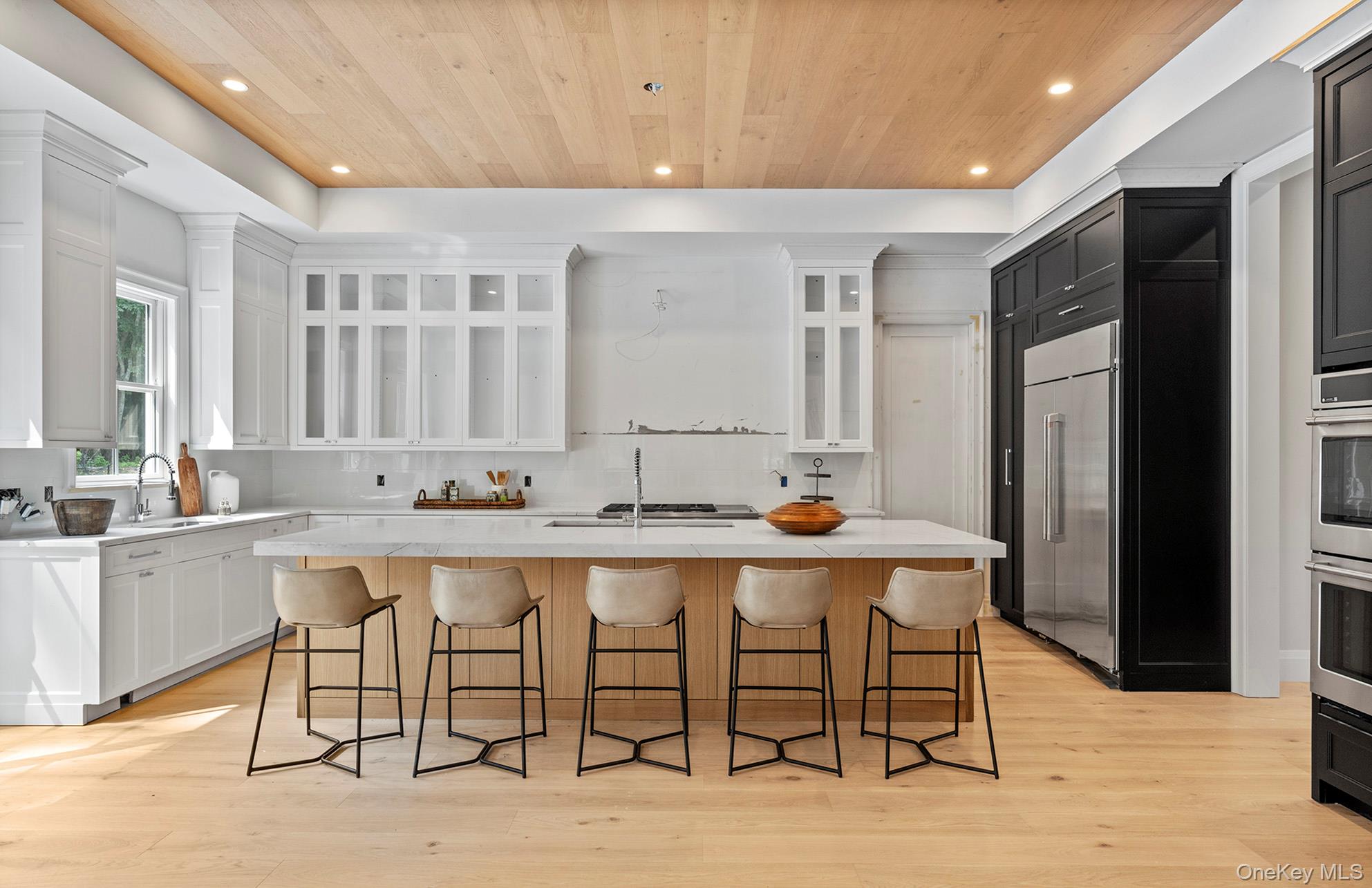 2524 Noyack Road Sag Harbor, NY 11963 - Photo 14 of 38 a large white kitchen with a table and chairs
