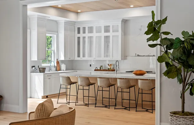 a living room with furniture a potted plant and a large window
