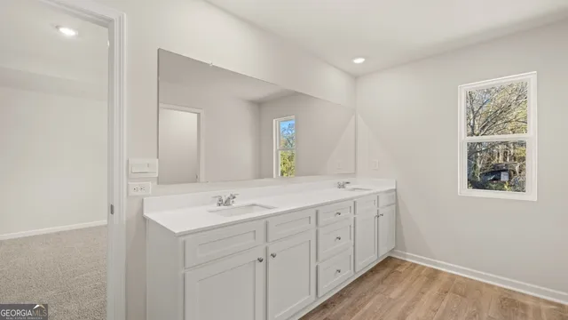 a spacious bathroom with 2 sink and a mirror