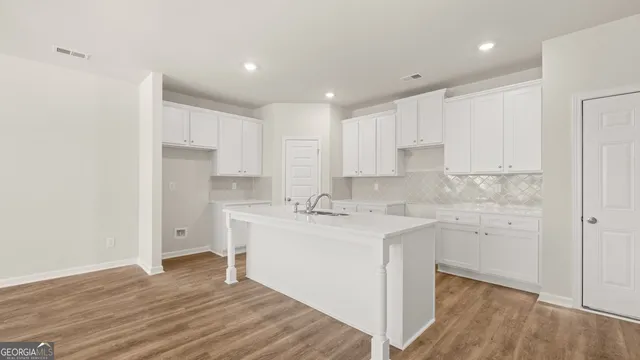 a kitchen with a sink cabinets and wooden floor