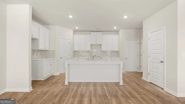 a kitchen with a refrigerator sink and cabinets