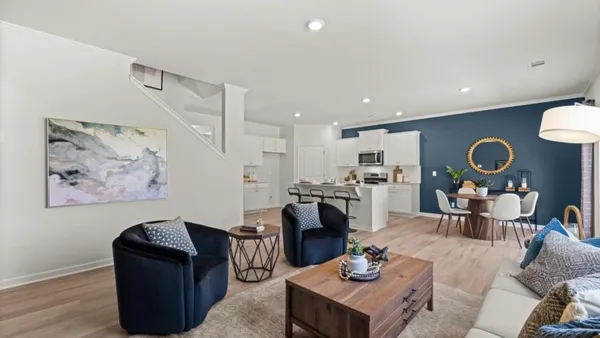 a living room with furniture and kitchen view