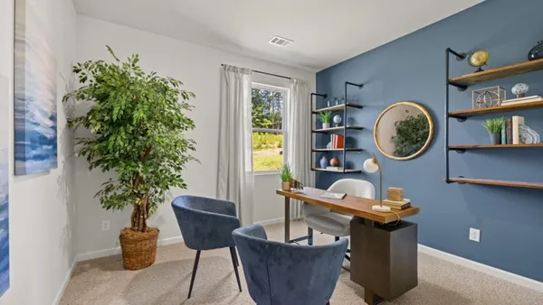 a living room with furniture a potted plant and a window