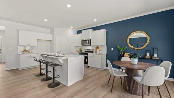 a kitchen with a dining table chairs and wooden floor