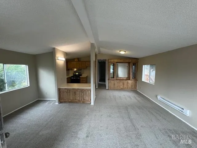 a large kitchen with wooden floor and cabinets