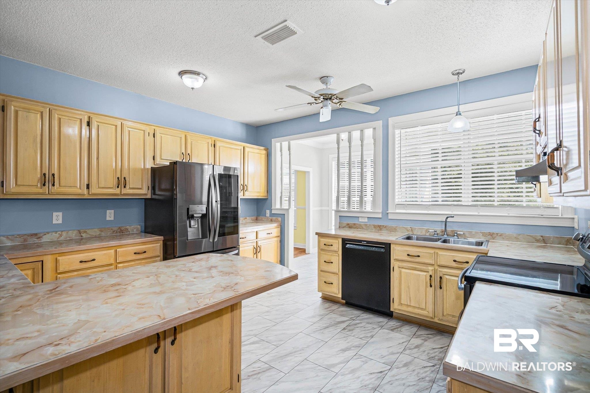 7650 Iron Rush Road Wilmer, AL 36587 - Photo 11 of 34 Kitchen featuring light countertops, black appliances, light brown cabinets, pendant lighting, and a textured ceiling