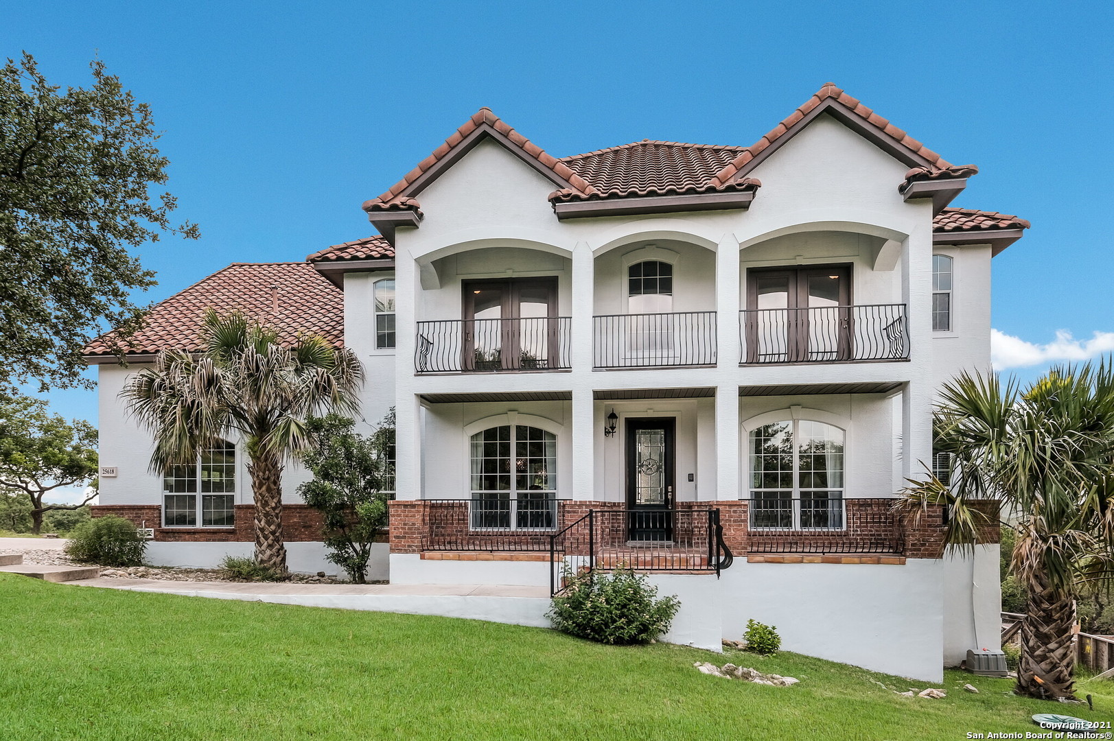 a front view of a house with a yard and trees