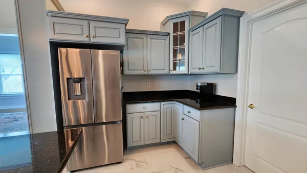 a kitchen with a refrigerator sink and cabinets