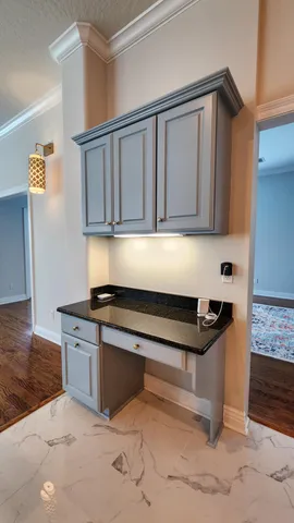 a kitchen with granite countertop a sink cabinets and stainless steel appliances