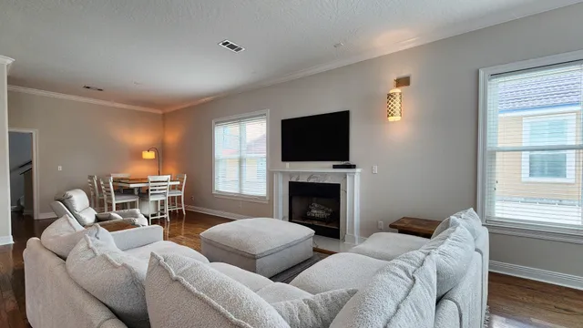 a living room with furniture a flat screen tv and a fireplace