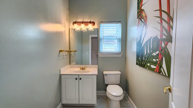 a bathroom with a toilet sink and mirror