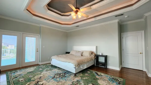 a bedroom with a bed and a table with wooden floor