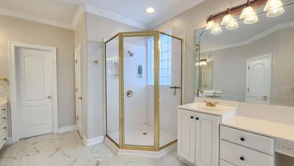 a bathroom with a glass shower door and a mirror