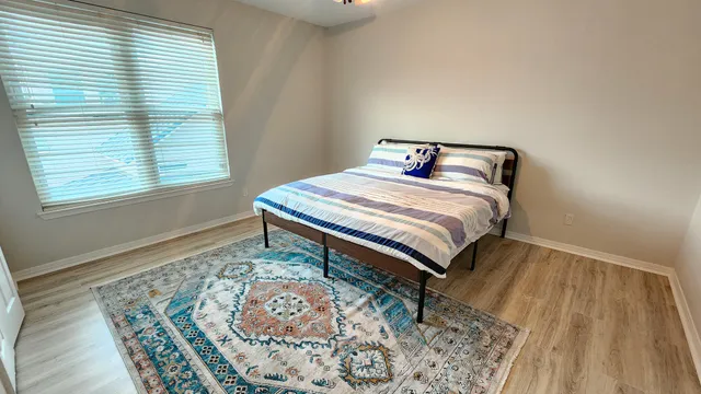 a bedroom with a bed and wooden floor