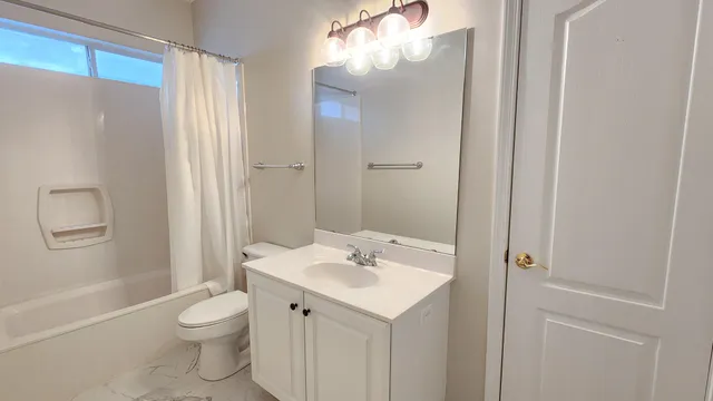 a bedroom with a bed lamp and a large window