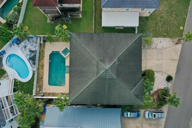 an aerial view of a house with swimming pool and wooden fence