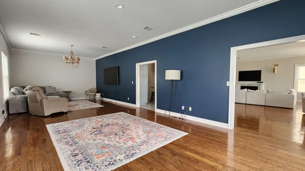 a living room with furniture and a wooden floor