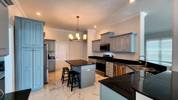 a kitchen with stainless steel appliances granite countertop a sink a stove and a refrigerator