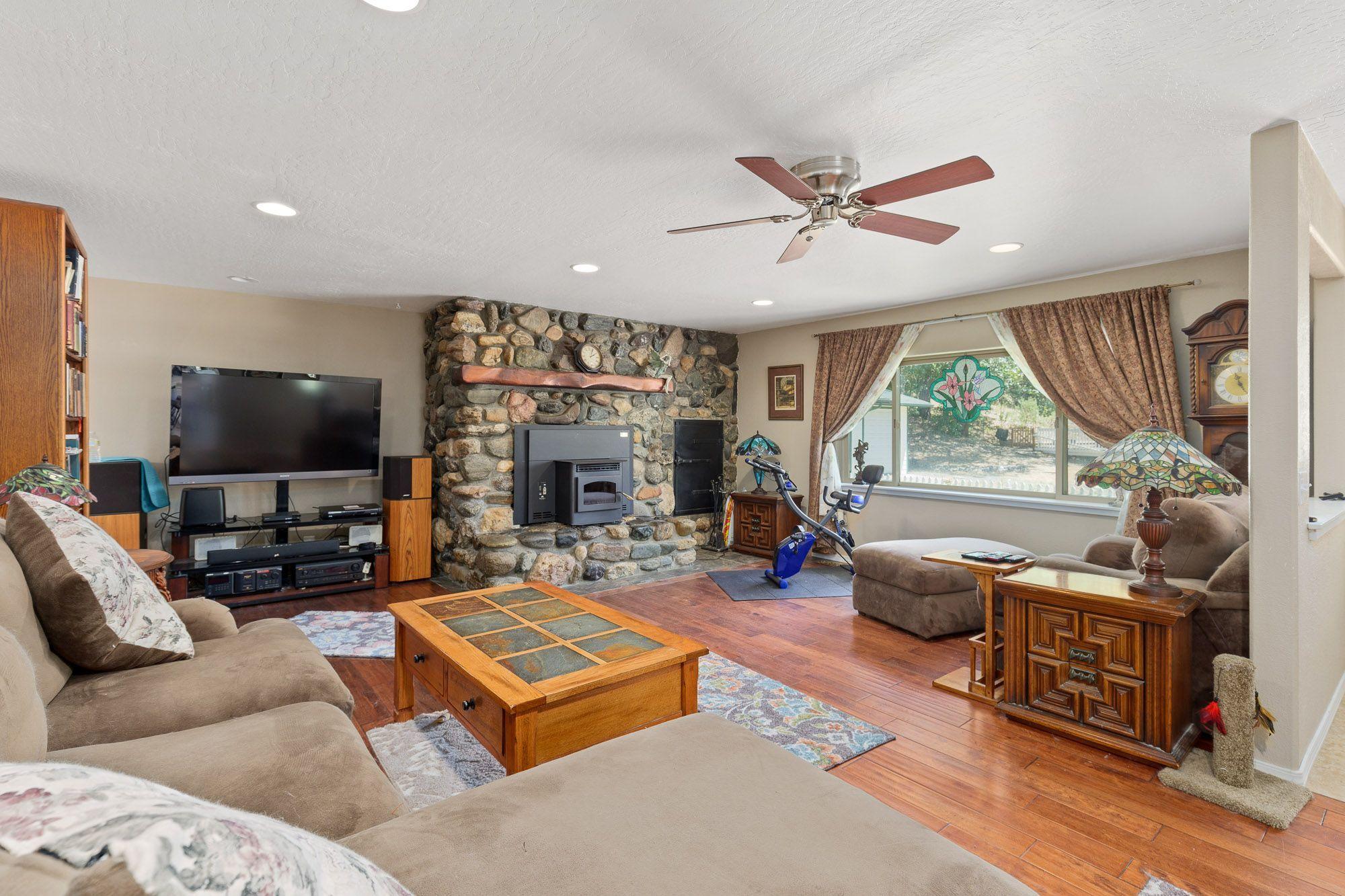 9266 Lower River Road Grants Pass, OR 97526 - Photo 6 of 39 a living room with furniture a flat screen tv and a large window