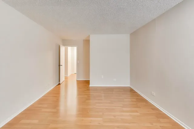 a view of an empty room with wooden floor