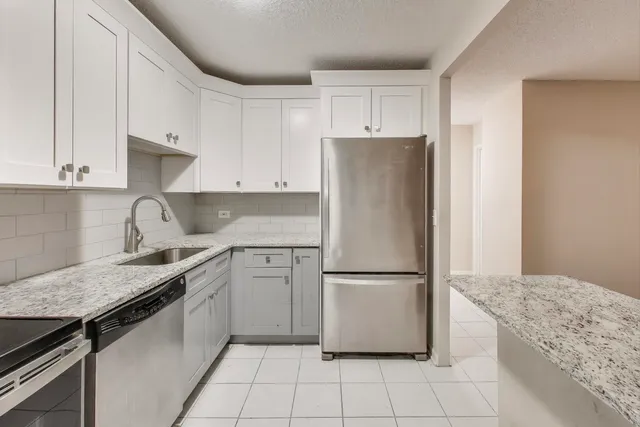 a kitchen with a refrigerator sink and cabinets