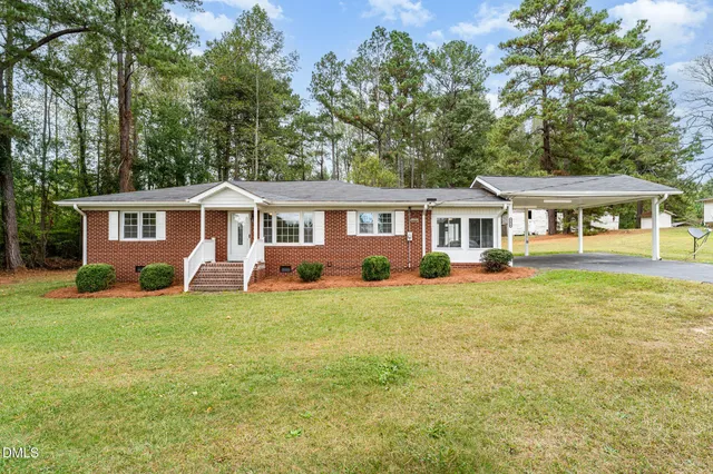 a front view of a house with a yard and trees
