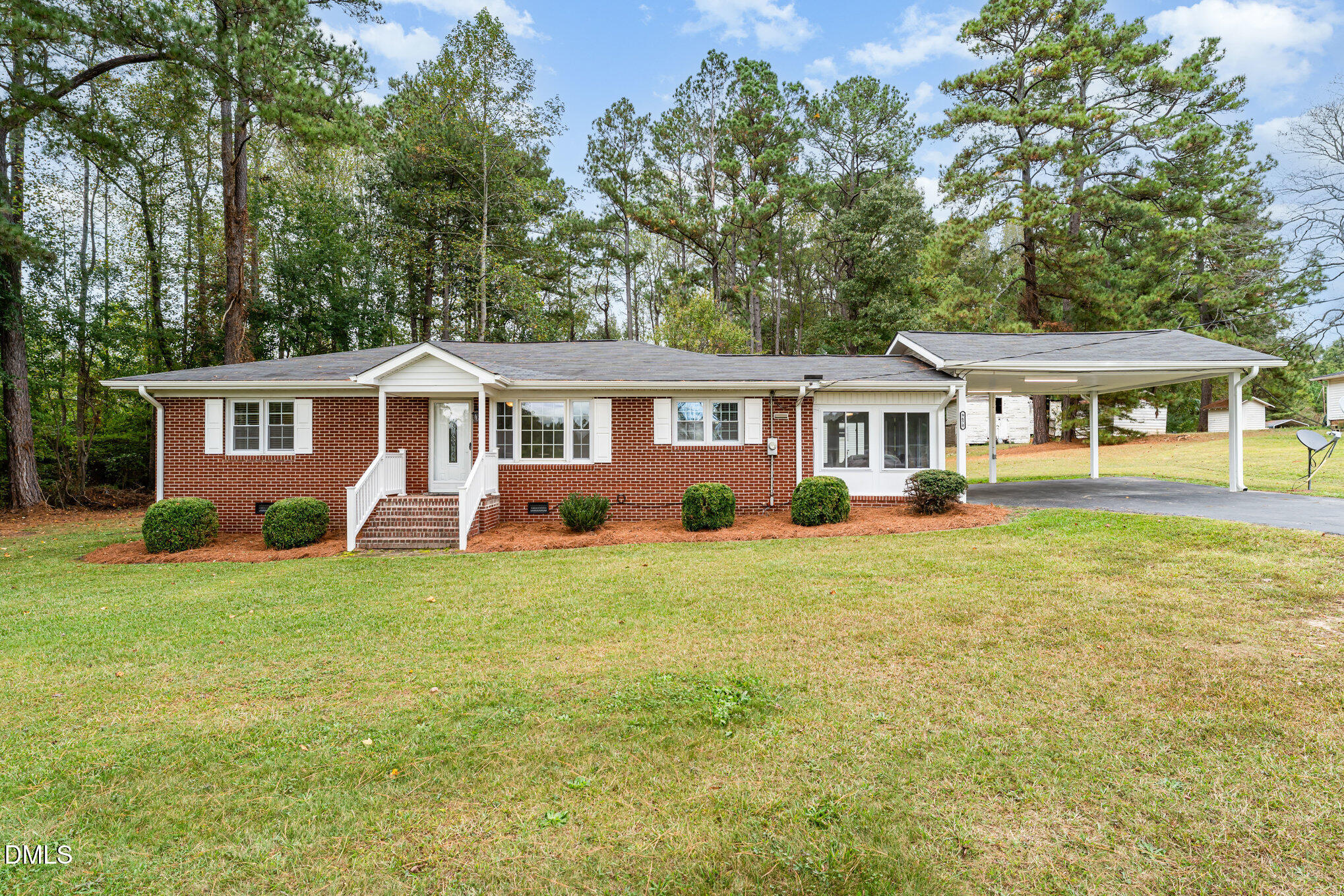 a front view of a house with a yard and trees