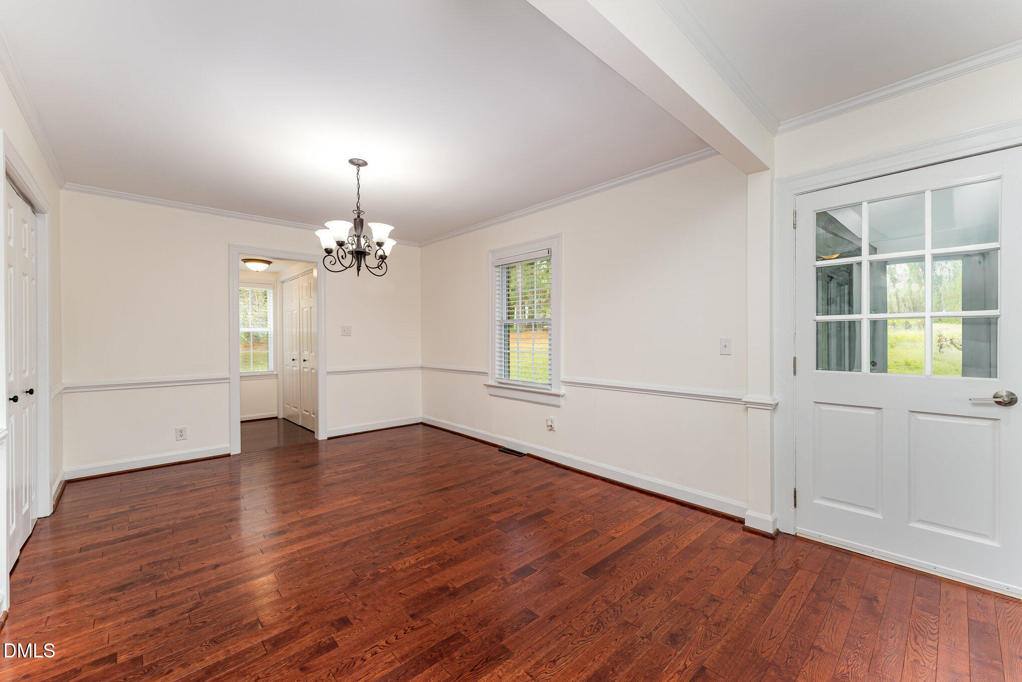 9670 Valley Road Middlesex, NC 27557 - Photo 8 of 22 an empty room with wooden floor chandelier and windows