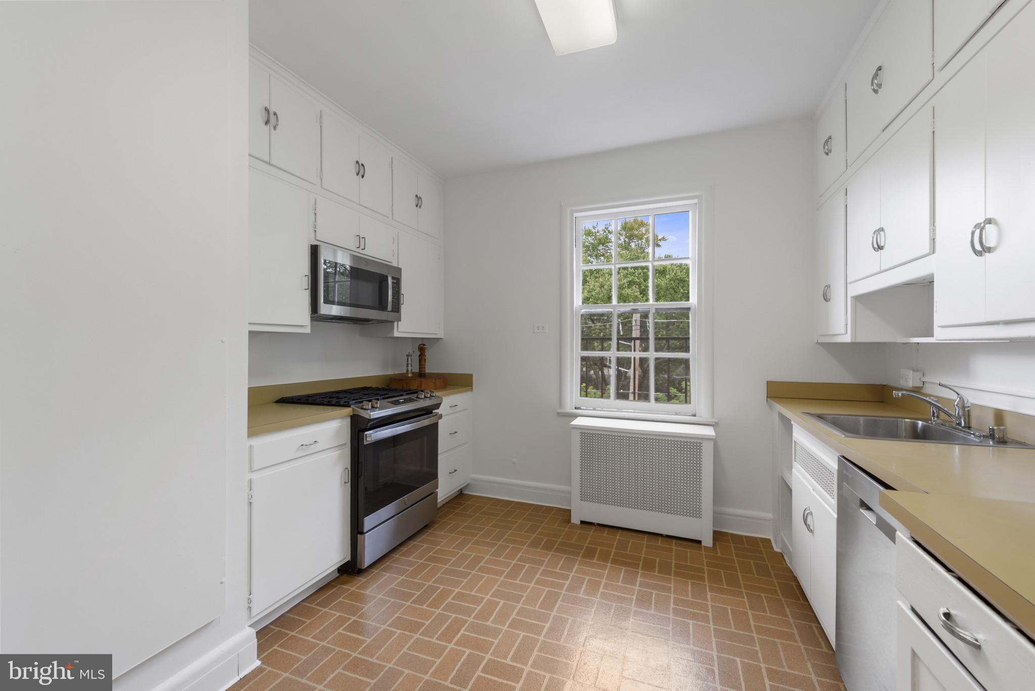 6 Upland Road, Unit F5 Baltimore, MD 21210 - Photo 11 of 31 a kitchen with a stove a sink and a microwave